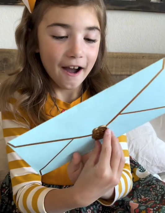 Young girl holding a fairy letter with a surprised expression